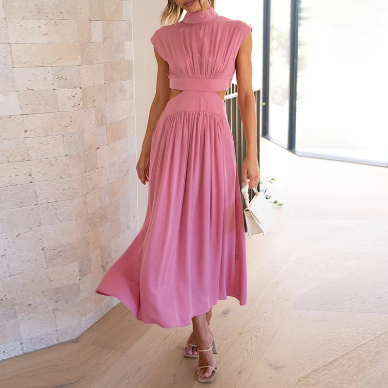 Abito lungo rosa elegante con cintura in vita, senza maniche, indossato da donna in interni moderni. Perfetto per eventi estivi e cerimonie.