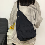 Zaino a tracolla nero su persona con felpa grigia, design casual, tasca con zip, ideale per viaggi e uso quotidiano.