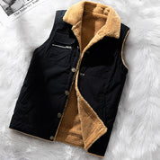 Gilet invernale nero con interno in pelliccia sintetica beige, chiusura a bottoni, tasche frontali, su sfondo bianco peloso. Moda uomo, abbigliamento caldo.