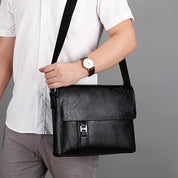 Uomo con camicia bianca indossa borsa a tracolla in pelle nera, elegante e moderna, ideale per lavoro e ufficio. Accessorio moda maschile.