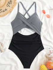 Costume intero donna a righe bianche e nere, design incrociato, su sfondo bianco con accessori estivi. Moda mare, abbigliamento da spiaggia.