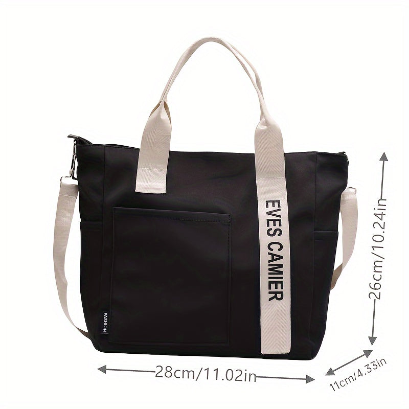 Borsa tote nera in tessuto con manici bianchi, tasca frontale, dimensioni 28x26x11 cm, design moderno, ideale per shopping e uso quotidiano.