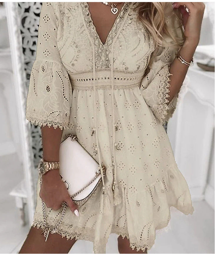 Abito estivo in pizzo beige con maniche a tre quarti, scollo a V e dettagli floreali. Accessoriato con borsa bianca a tracolla.