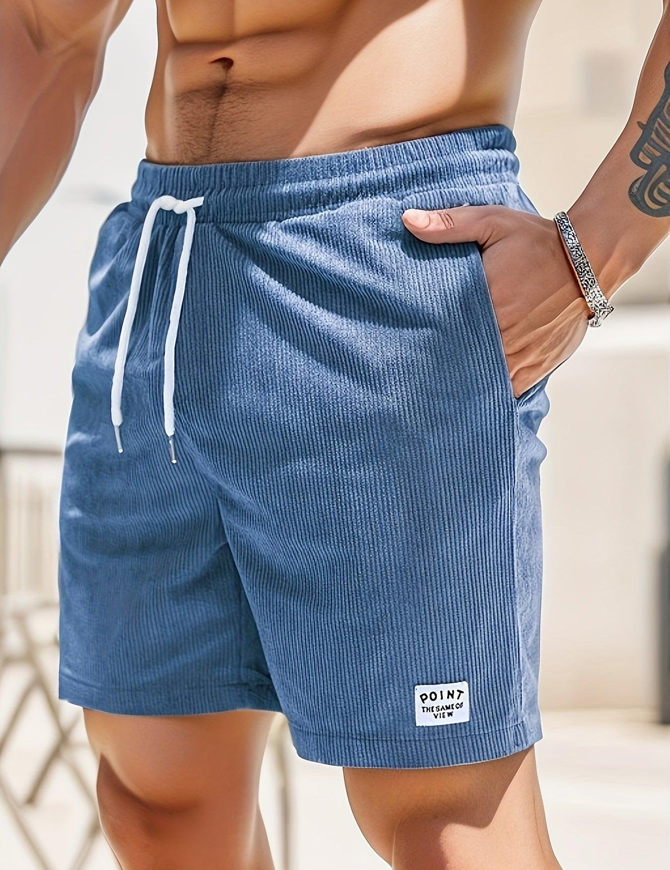 Shorts da uomo blu in tessuto a coste, con laccio bianco in vita e tasche laterali. Ideali per l'estate e il tempo libero.