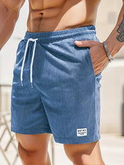 Pantaloncini da uomo blu in tessuto a coste, con laccio bianco in vita e tasche laterali. Ideali per l'estate e il tempo libero.