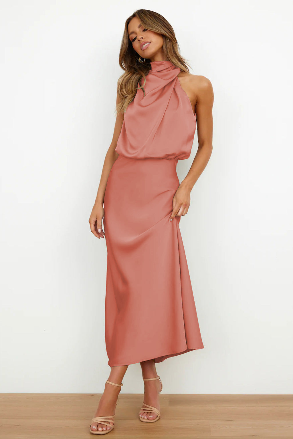 Abito lungo elegante rosa salmone con scollo all'americana, indossato da donna in piedi. Perfetto per eventi formali e serate speciali.