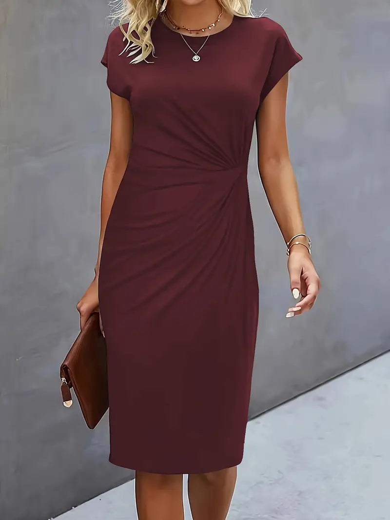 Abito midi elegante bordeaux da donna, con maniche corte e drappeggio laterale, perfetto per occasioni formali. Accessoriato con pochette marrone.