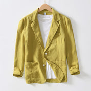 Giacca blazer gialla da uomo in cotone, stile casual, con tasche frontali e bottoni bianchi, appesa su gruccia, sfondo bianco.