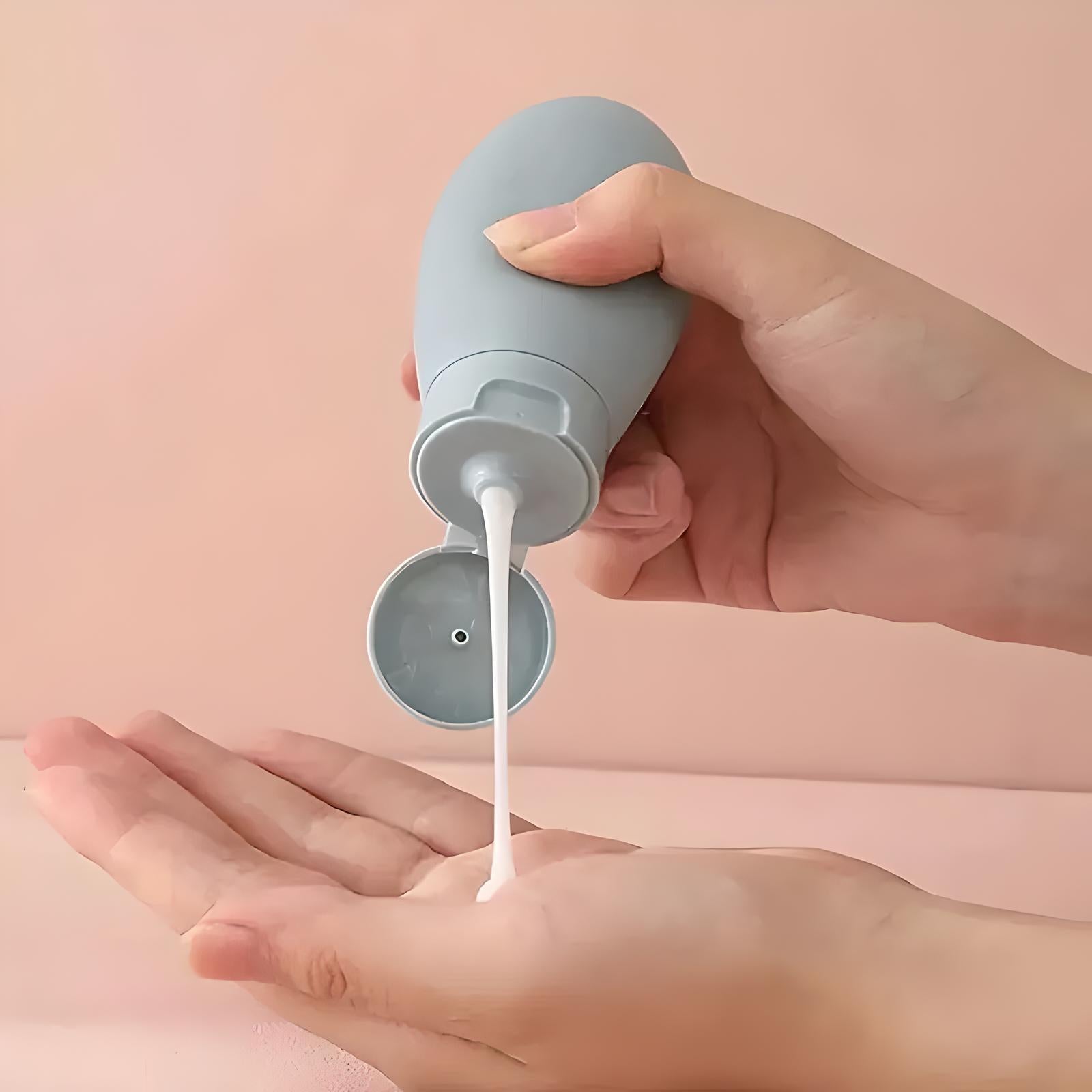 Mano che versa lozione bianca da flacone grigio su sfondo rosa. Cura della pelle, idratazione, cosmetici, bellezza quotidiana.