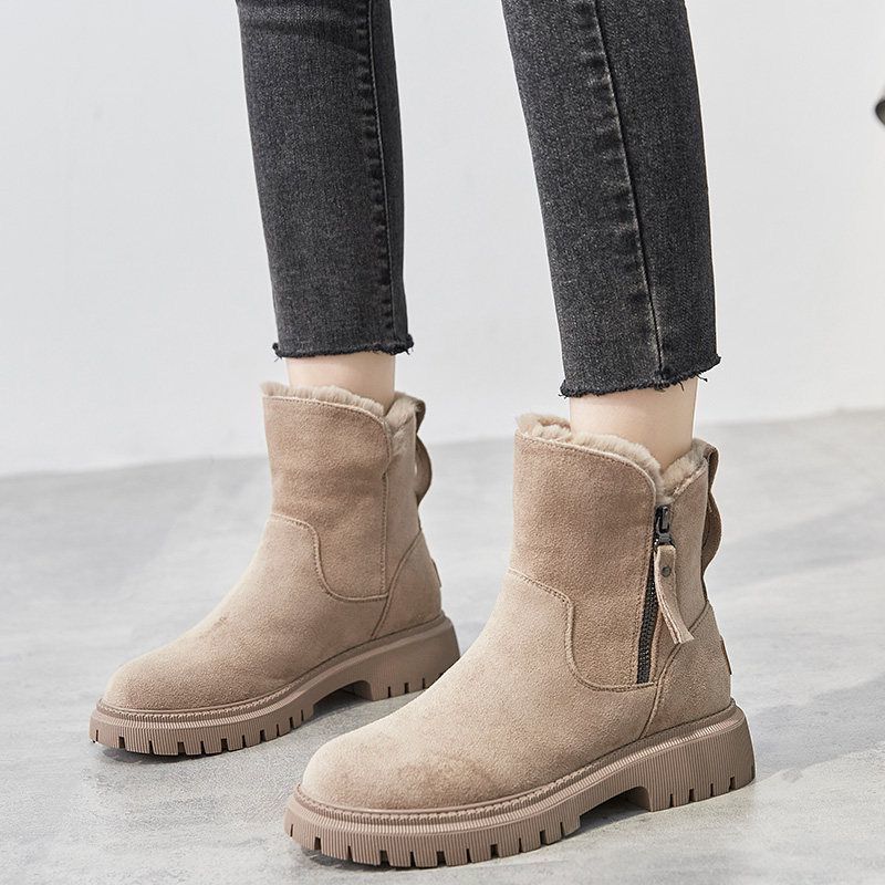 Stivaletti beige in pelle scamosciata con zip laterale, suola in gomma antiscivolo, indossati con jeans neri. Scarpe invernali moda donna.