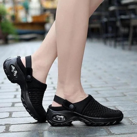 Scarpe da donna nere con tacco ammortizzato, design sportivo e traspirante, ideali per camminate e attività all'aperto su pavimentazione urbana.