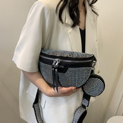 Donna con borsa a tracolla nera con borchie argentate, abbinata a un portamonete rotondo. Moda elegante, accessori femminili di tendenza.
