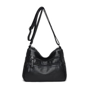 Borsa a tracolla in pelle nera con cerniere multiple, design elegante e pratico. Accessorio moda donna, ideale per uso quotidiano.
