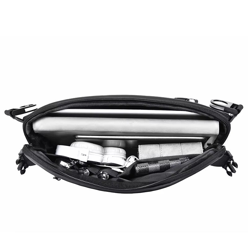Borsa a tracolla nera aperta con laptop, cuffie, portafoglio e accessori. Design compatto, ideale per lavoro e viaggio. Tasche organizzate.
