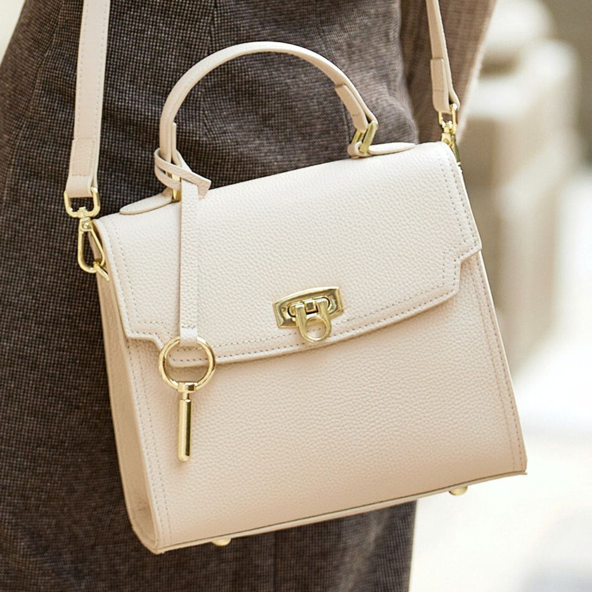 Borsa a tracolla in pelle bianca con chiusura dorata, design elegante e moderno, ideale per moda femminile e accessori di lusso.