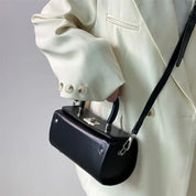 Giacca bianca elegante con borsa a tracolla nera in pelle, design moderno, chiusura metallica, moda uomo, accessorio di tendenza.