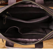 Interno di borsa in pelle marrone con cerniera, tasche multiple e scomparti organizzativi. Design elegante e funzionale per uso quotidiano.