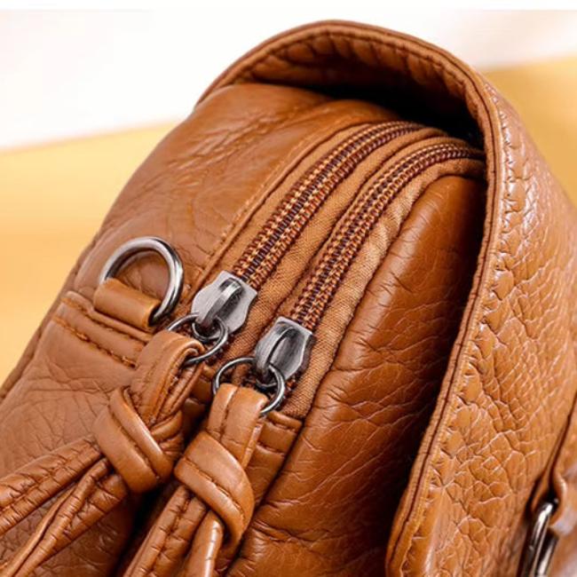Borsa a tracolla in pelle marrone con doppia cerniera e dettagli in metallo argentato. Design elegante e pratico per moda donna.