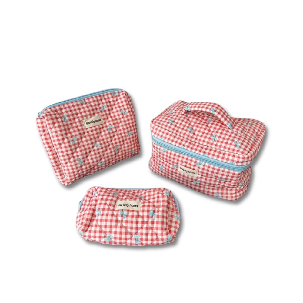 Set di tre beauty case a quadretti rossi e bianchi con cerniera, manico e dettagli blu, ideale per viaggi e organizzazione cosmetici.