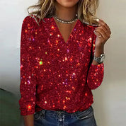 Maglia rossa con paillettes scintillanti, maniche lunghe, scollo a V, indossata da donna. Perfetta per feste e occasioni speciali.