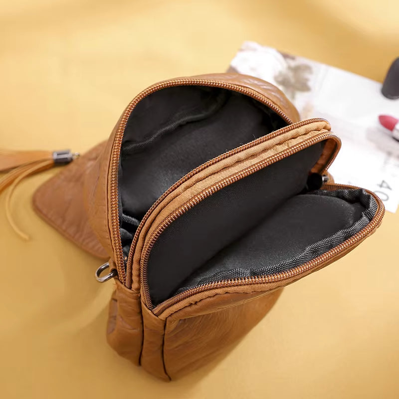 Borsa a tracolla in pelle marrone con cerniere aperte, design elegante e compatto, ideale per moda donna. Accessorio versatile e di tendenza.