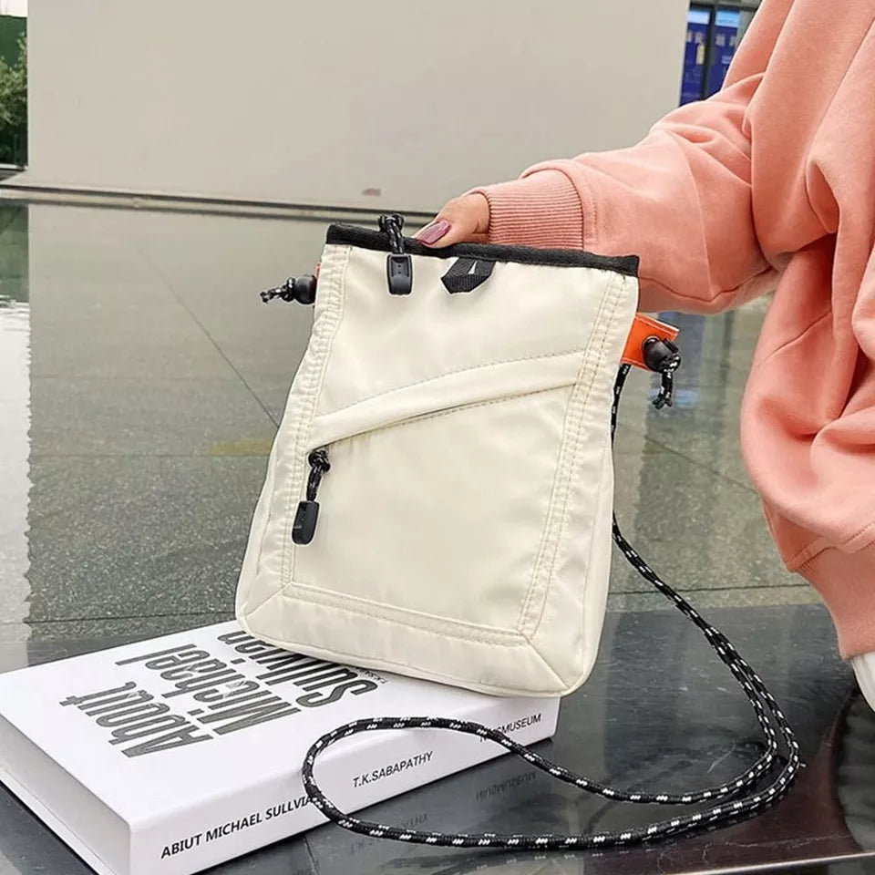 Borsa a tracolla bianca in nylon con zip, design moderno, indossata da una persona in felpa rosa. Accessorio moda casual, ideale per shopping.