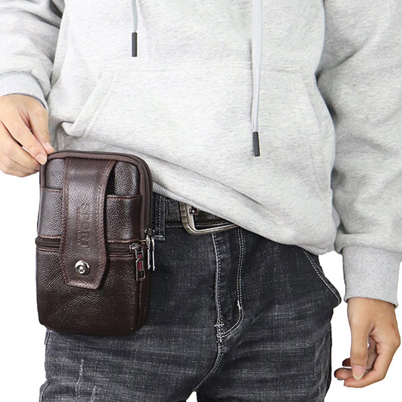 Marsupio in pelle marrone per uomo, indossato su jeans neri e felpa grigia. Accessorio moda pratico, ideale per viaggi e uso quotidiano.