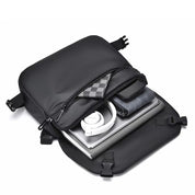Zaino nero aperto con laptop, cuffie bianche, smartphone e accessori. Design moderno, ideale per lavoro e viaggio. Tasche multiple, resistente.