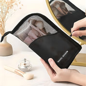 Astuccio nero da viaggio per cosmetici con cerniera, contenente pennelli trucco. Accessorio essenziale per organizzare il make-up in viaggio.