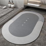 Tappeto da bagno ovale grigio con scritta "HOME", design moderno, antiscivolo, ideale per bagno elegante, pavimento in piastrelle.