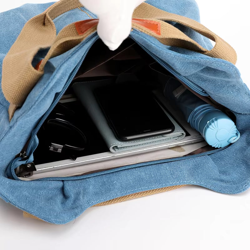 Zaino in tela blu aperto, mostra contenuto: smartphone, quaderno, bottiglia d'acqua, cavi. Ideale per scuola, lavoro, viaggio. Accessori organizzati.