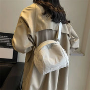 Cappotto beige donna con borsa a tracolla bianca in tessuto a coste, moda autunno, stile casual, accessori femminili eleganti.