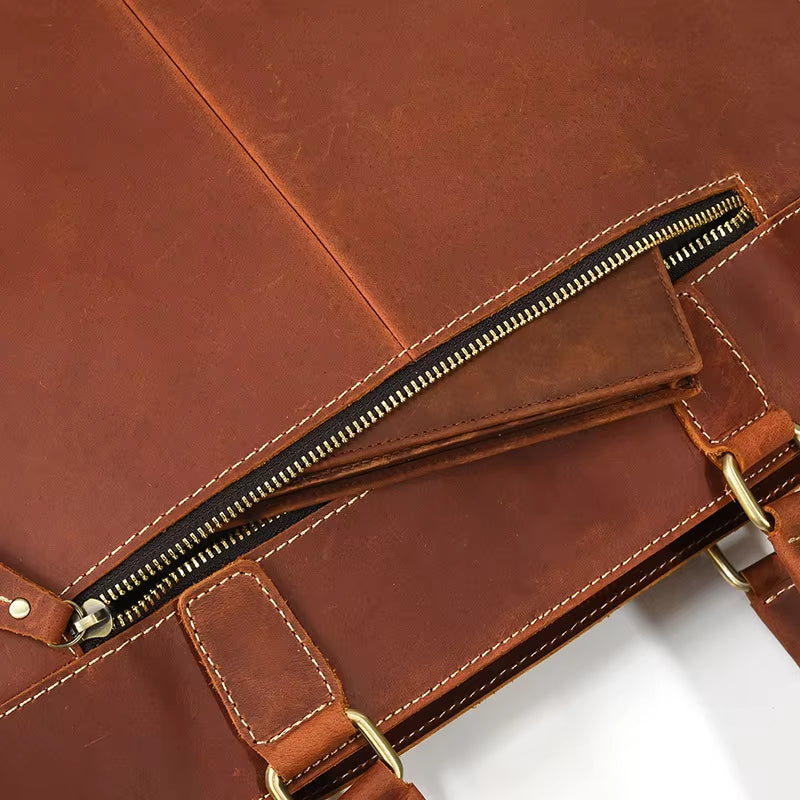 Borsa in pelle marrone con cerniera dorata, cuciture bianche e manici robusti. Design elegante e resistente, ideale per lavoro e viaggio.