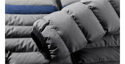 Giacca invernale imbottita grigia, dettaglio manica, tessuto impermeabile, design trapuntato, moda uomo, abbigliamento caldo e resistente.
