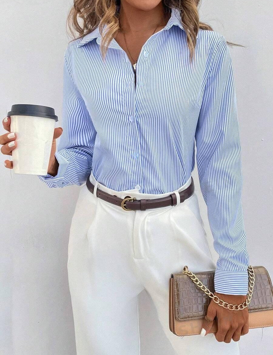 Donna con camicia a righe blu e bianche, pantaloni bianchi eleganti, cintura marrone, borsa a tracolla beige e caffè da asporto. Moda casual chic.