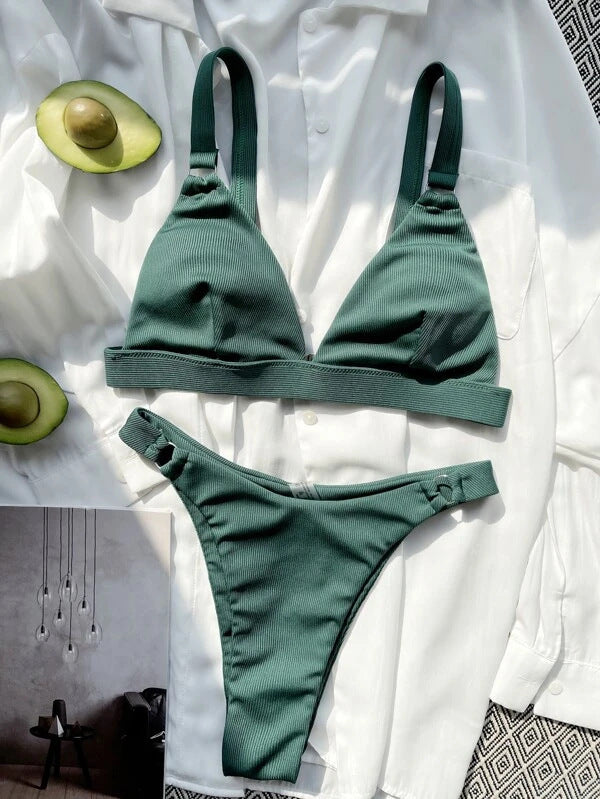 Bikini verde a costine su camicia bianca, con avocado tagliato a metà. Moda mare donna, costumi da bagno estivi, tendenze beachwear 2023.