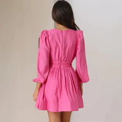 Abito corto rosa con maniche lunghe a sbuffo, vita arricciata, tessuto leggero. Perfetto per moda femminile, abbigliamento estivo elegante.