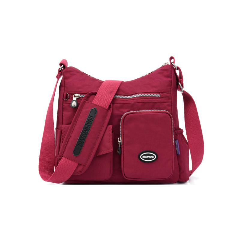 Borsa a tracolla rossa in nylon con tasche multiple, cerniere e tracolla regolabile. Design casual, ideale per donna. Accessorio moda pratico.