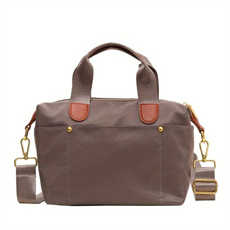 Borsa a mano in tessuto marrone con manici e tracolla regolabile, dettagli in pelle marrone chiaro, accessori in metallo dorato. Elegante e versatile.