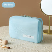 Astuccio trucco azzurro su tavolo con specchio e pennelli. Borsa cosmetica elegante, ideale per organizzare prodotti di bellezza.