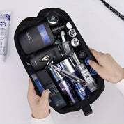 Borsa da toilette aperta con prodotti per la cura personale maschile: rasoio, flaconi di profumo, creme e lozioni. Accessori da viaggio uomo.