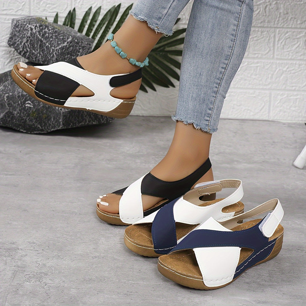 Sandali donna estivi in pelle, design bicolore bianco e nero, suola in legno, indossati con jeans. Scarpe comode e alla moda per l'estate.