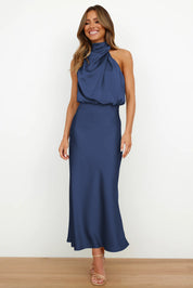Abito lungo blu elegante con scollo all'americana, indossato da una donna sorridente. Perfetto per eventi formali e serate speciali.