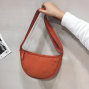 Borsa a tracolla arancione, design minimalista, tessuto leggero, chiusura con zip, ideale per moda casual e viaggi. Accessorio trendy unisex.