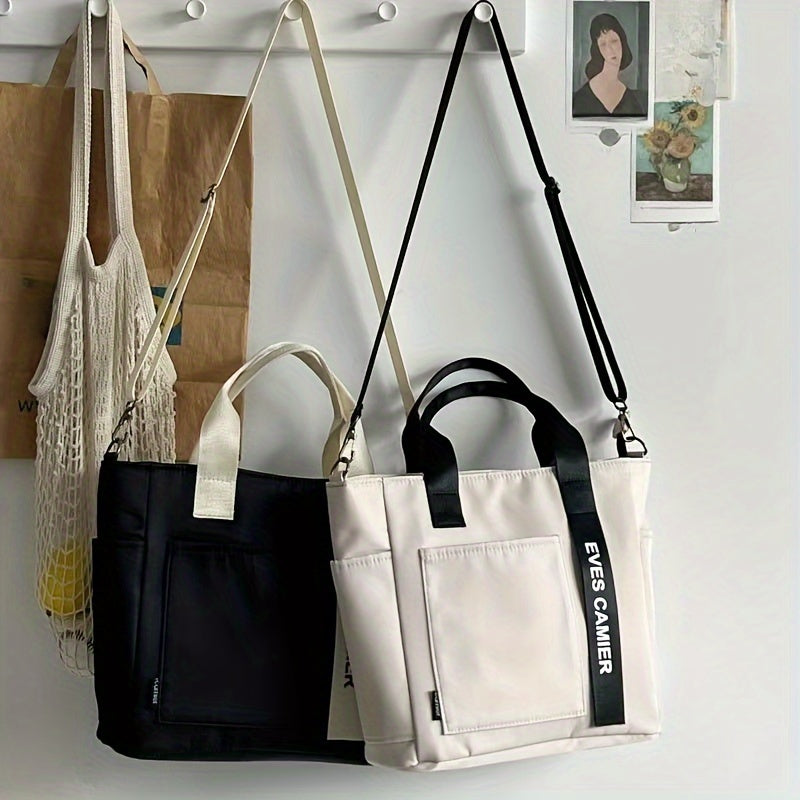 Due borse a tracolla in pelle, una nera e una bianca, appese a un gancio. Design moderno, tasche frontali, manici robusti. Accessori moda eleganti.