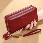Portafoglio donna in pelle rossa con doppia cerniera, cinturino da polso, design elegante, ideale per moda e accessori femminili.