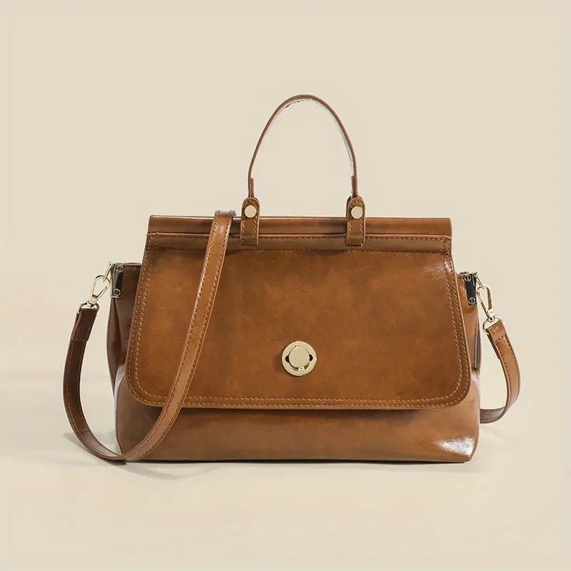 Borsa a mano in pelle marrone con tracolla regolabile, chiusura a scatto dorata, design elegante e spazioso. Accessorio moda donna.