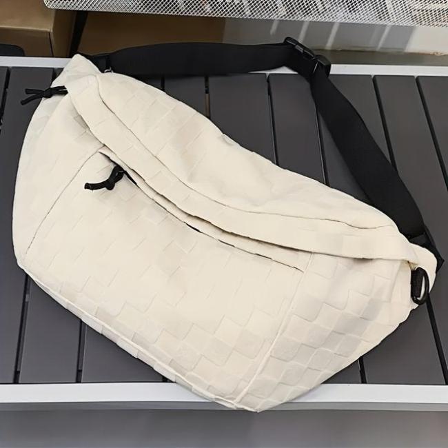 Borsa a tracolla bianca in tessuto trapuntato, design moderno, con cinghia regolabile nera. Accessorio moda unisex, ideale per uso quotidiano.