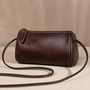 Borsa a tracolla cilindrica in pelle marrone scuro, design elegante e minimalista, perfetta per moda donna, accessori di lusso, stile casual chic.