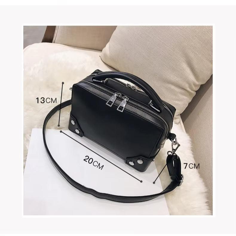 Borsa a tracolla nera in pelle, dimensioni 20x13x7 cm, con doppia zip e manico superiore, su sfondo chiaro. Accessorio moda elegante e versatile.